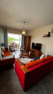 Sala de estar con 2 sofás y TV en Balnea Villa Sixty-Nine, en Trou d'Eau Douce