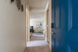 a hallway with a blue door and a living room at Beautiful and cozy one bedroom apartment -WiFi, BBQ, Patio, Dog park, close to Greenlake and Northgate in Seattle