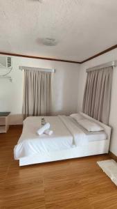 a white bed in a room with a window at Amanzara Bohol Resort in Bolod