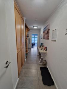 um corredor com uma porta e uma mesa num quarto em Ferienwohnung Blick am Tief 4 Sterne em Dornum