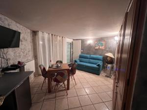 - un salon avec un canapé bleu et une table dans l'établissement Villa Chapulay, à Valencin