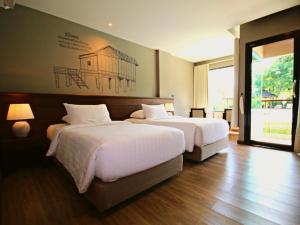 um quarto com duas camas e um quadro na parede em River Tree Resort em Chiang Khan