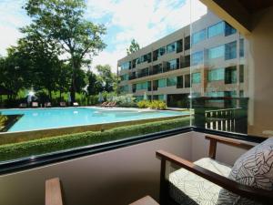 - Balcón con vistas a la piscina y al edificio en River Tree Resort en Chiang Khan