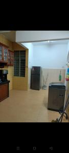 a kitchen with a refrigerator and a counter top at Leeza Homestay in Kampung Kempadang