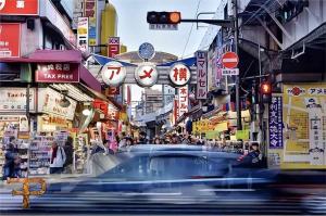 un coche conduciendo por una calle en una ciudad en 东京上野超级中心 设计师房间Ybob 上野公园3分钟 车站1分钟 超级繁华 免费wifi 戴森吹风 en Tokio