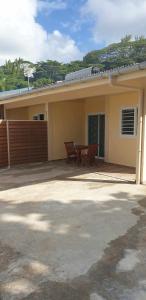 ein Haus mit einer Terrasse und einem Tisch davor in der Unterkunft Ohana RBNB studio "Havai " in Uturoa