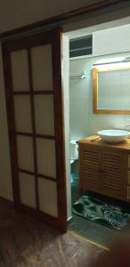 a bathroom with a door open to a sink at Ohana RBNB studio "Havai " in Uturoa