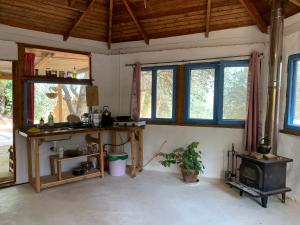 a kitchen with a stove in a room with windows at the Meshushe in Kadita