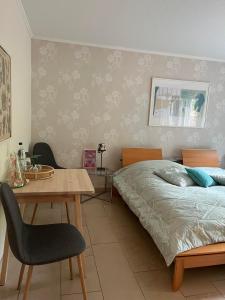 Schlafzimmer mit einem Bett, einem Holztisch und einem Stuhl in der Unterkunft Bei Annemarie in Trier