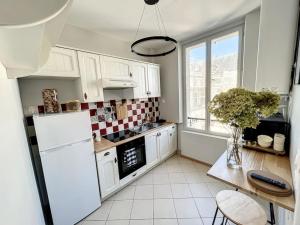 a kitchen with a white refrigerator and a table at Le Agathe - Urbain et Bohème in Compiègne