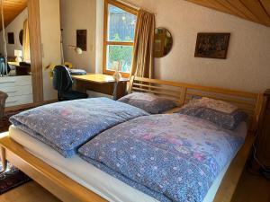 a bedroom with a bed and a desk and a window at Bijou Guest House in Mieders