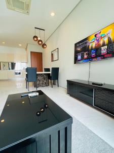 a living room with a ping pong table and a tv at SOHO Suites KLCC in Kuala Lumpur
