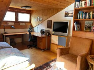 a bedroom with a bed and a desk and a television at Bijou Guest House in Mieders