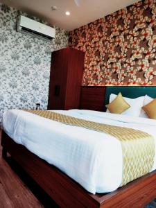 1 dormitorio con 1 cama blanca grande en una habitación en HOTEL KIRAN INN, en Ahmedabad