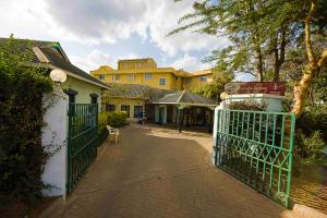 ein Tor zu einem Haus mit einem Gebäude im Hintergrund in der Unterkunft Acacia Resort Wote-Makueni by Nest & Nomad in Wote