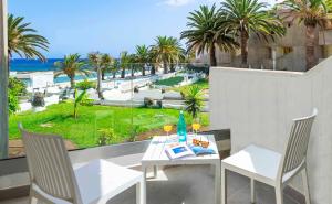 a table and chairs on a balcony with a view of the ocean at Ona Alborada in Costa Del Silencio