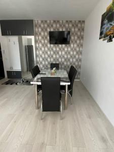 une salle à manger avec une table et des chaises noires dans l'établissement Apartament tip studio, à Roşu