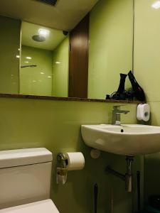 a bathroom with a sink and a toilet and a mirror at SOHO Suites KLCC in Kuala Lumpur