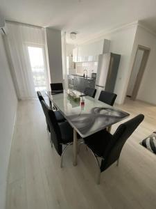 mesa de comedor con sillas y cocina en Apartament tip studio, en Roşu