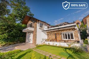 德拉敦SaffronStays Polaris, Dehradun - pet-friendly Swedish home amidst nature的前面有草坪的房子