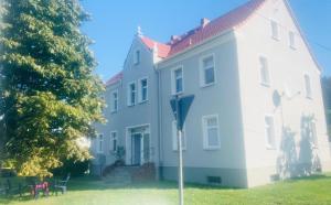 a white house with a parking meter in front of it at Berzi Ferienwohnung 001 Görlitz in Markersdorf