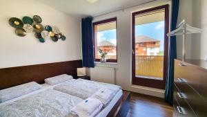 ein Schlafzimmer mit einem Bett und einem großen Fenster in der Unterkunft Apartmán Beskydy in Čeladná