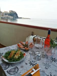 una mesa con una ensalada y un plato de comida en Balcone sul mare, en Scilla