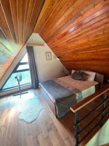 1 dormitorio con cama y techo de madera en Forest house, en Gabala