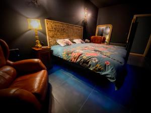 a bedroom with a bed and a chair and a lamp at Loveroom avec jacuzzi 01 in Chazey-sur-Ain
