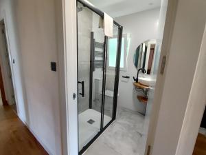a bathroom with a glass shower and a sink at Chalet Las Llamas in Llanes