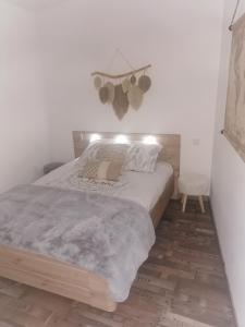 ein Schlafzimmer mit einem großen Bett und Holzboden in der Unterkunft Logement cosy avec piscine et jacuzzi privatifs 4 étoiles in Saint-Dolay