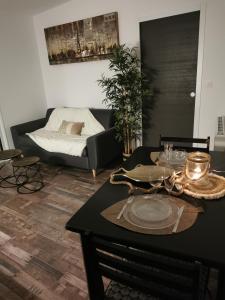 ein Wohnzimmer mit einem Tisch und einem Sofa in der Unterkunft Logement cosy avec piscine et jacuzzi privatifs 4 étoiles in Saint-Dolay