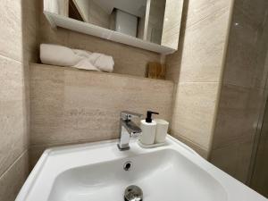 lavabo con grifo y toallas en Revesen Premium Apartments, en Cracovia