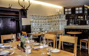 um restaurante com mesas e cadeiras de madeira e uma lareira em Krone - das Gasthaus em Kirchhofen