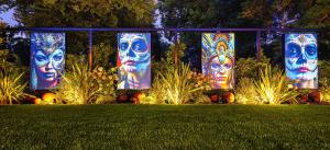 a group of banners with faces on them in a yard at Amicitia - Hôtel & Restaurant in LʼIsle-Adam
