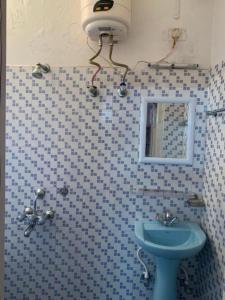 ein Badezimmer mit einem blauen Waschbecken und einem Spiegel in der Unterkunft Stay Inn Belle Vue House in Shillong