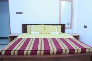 una camera da letto con un letto con materasso a righe di Imagine Villa Midigama a Midigama East