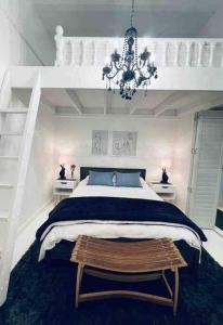 a bedroom with a large bed and a chandelier at Cottage, Nine on Windsor, Kalk Bay, Cape Town in Kalk Bay