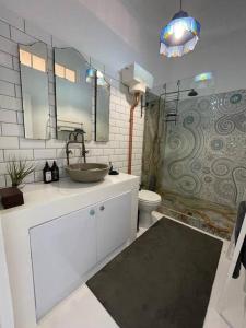 y baño con lavabo, aseo y espejo. en Cottage, Nine on Windsor, Kalk Bay, Cape Town, en Kalk Bay