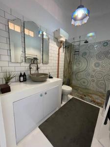 a bathroom with a sink and a toilet and a mirror at Cottage, Nine on Windsor, Kalk Bay, Cape Town in Kalk Bay