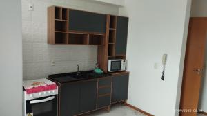 una pequeña cocina con fregadero y microondas en Apartamento Central, en Penha