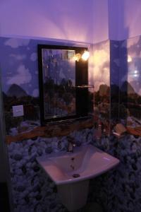 bagno con lavandino e finestra con rocce di Imagine Villa Midigama a Midigama East