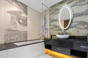 a bathroom with a sink and a mirror at Walaa Homes Stylish 1BR at DAMAC Esclusiva tower Riyadh-M07 in Riyadh