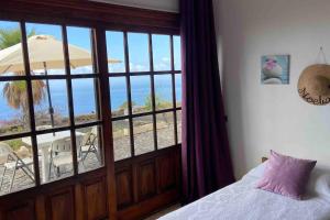 Aprtamento Rural El Pino في El Pinar del Hierro: غرفة نوم مع نافذة كبيرة مطلة على الشاطئ