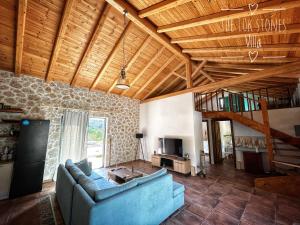 a living room with a blue couch and a wooden ceiling at The 10k Stones Villa in Corfu