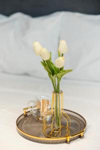 um vaso com flores brancas sobre uma mesa em Valaoritou 3 Luxury Rooms em Tessalónica
