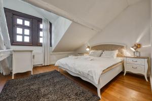 a white bedroom with a bed and a window at Apartments Old Town Gloria in Zagreb