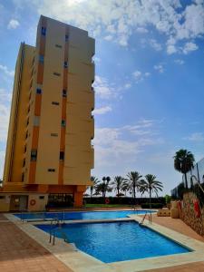 um hotel com piscina em frente a um edifício em SEAFRONT APARTMENT em Marbella