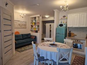 kuchnia i salon ze stołem i kanapą w obiekcie Apartament Klaudynka w mieście Jantar