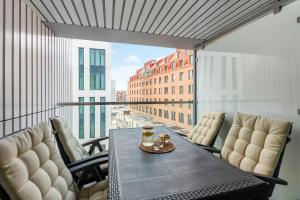 a table on a balcony with a view of a city at Downtown Apartments Riverside Granaria in Gdańsk